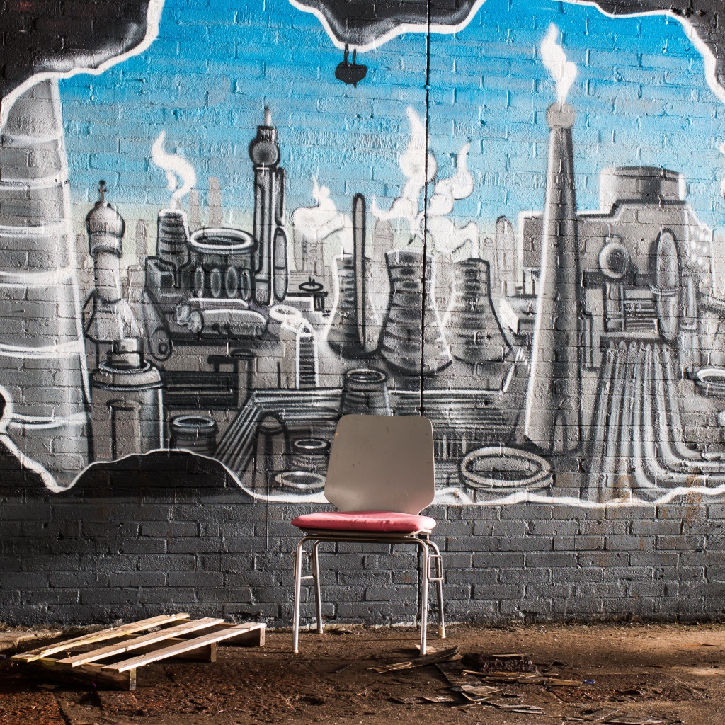 Стул стоит у кирпичной стены с граффити