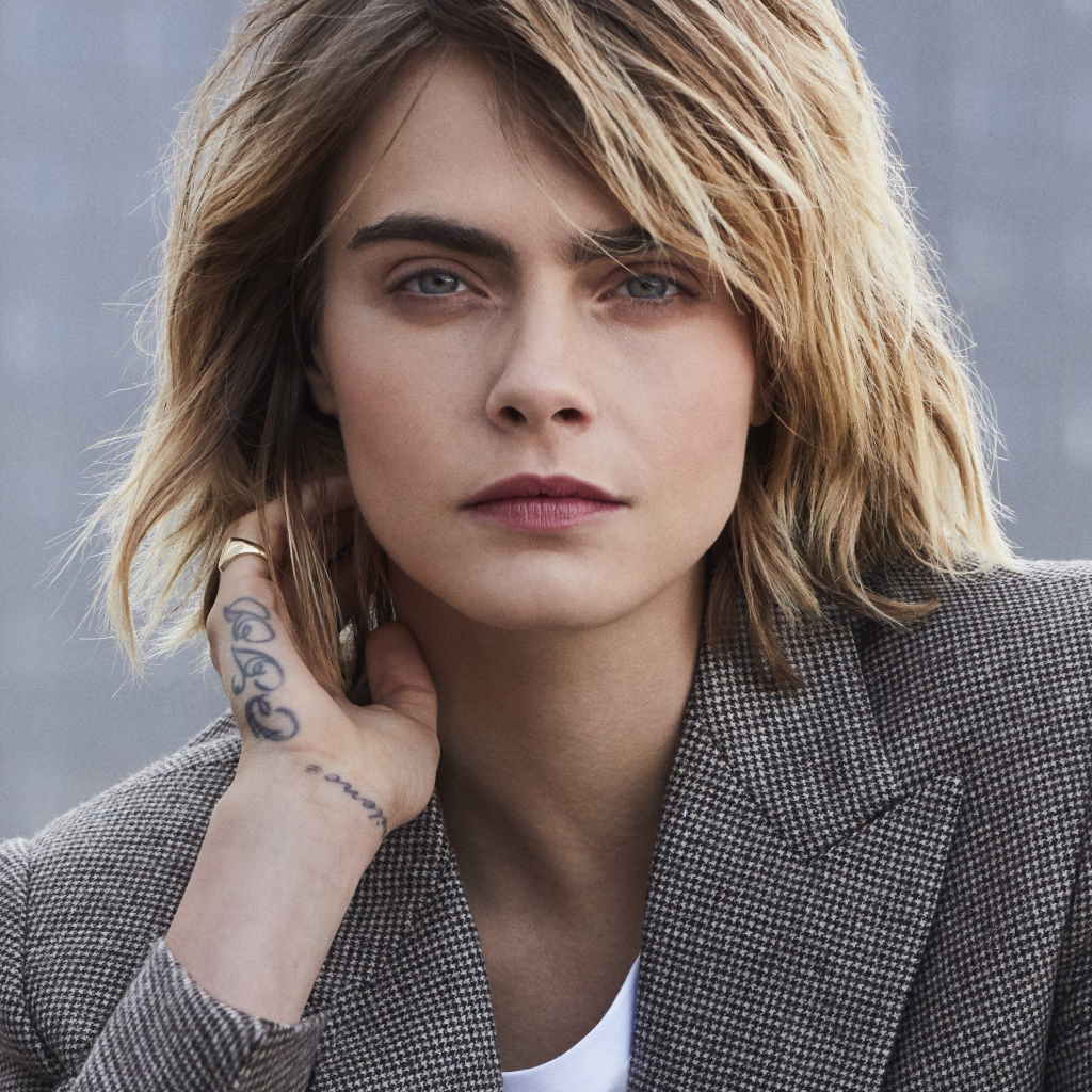 Актриса Кара Делевинь в пиджаке с татуировкой на руке