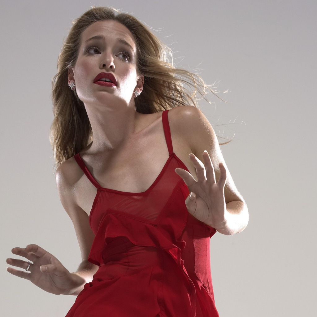 Actress Piper Perabo in a red dress on a gray background