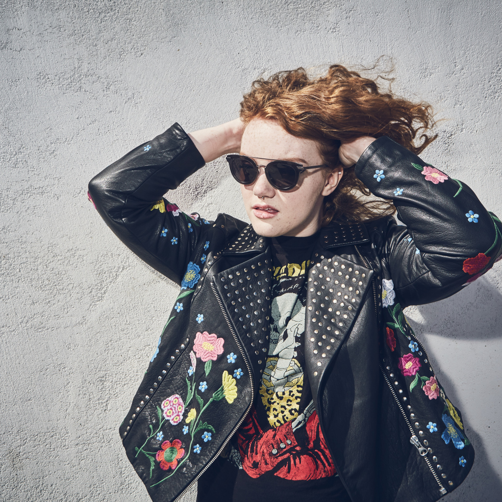 Актриса Шеннон Пёрсер в кожаной куртке у стены