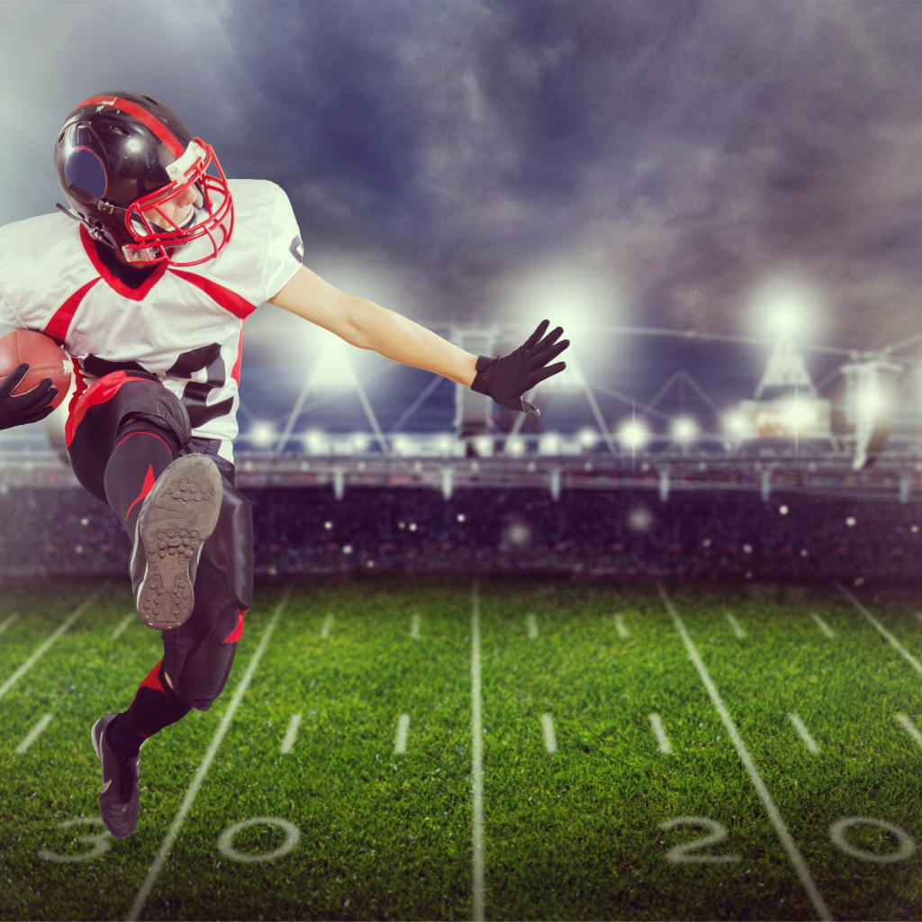 Игрок в американский футбол с мячом на поле