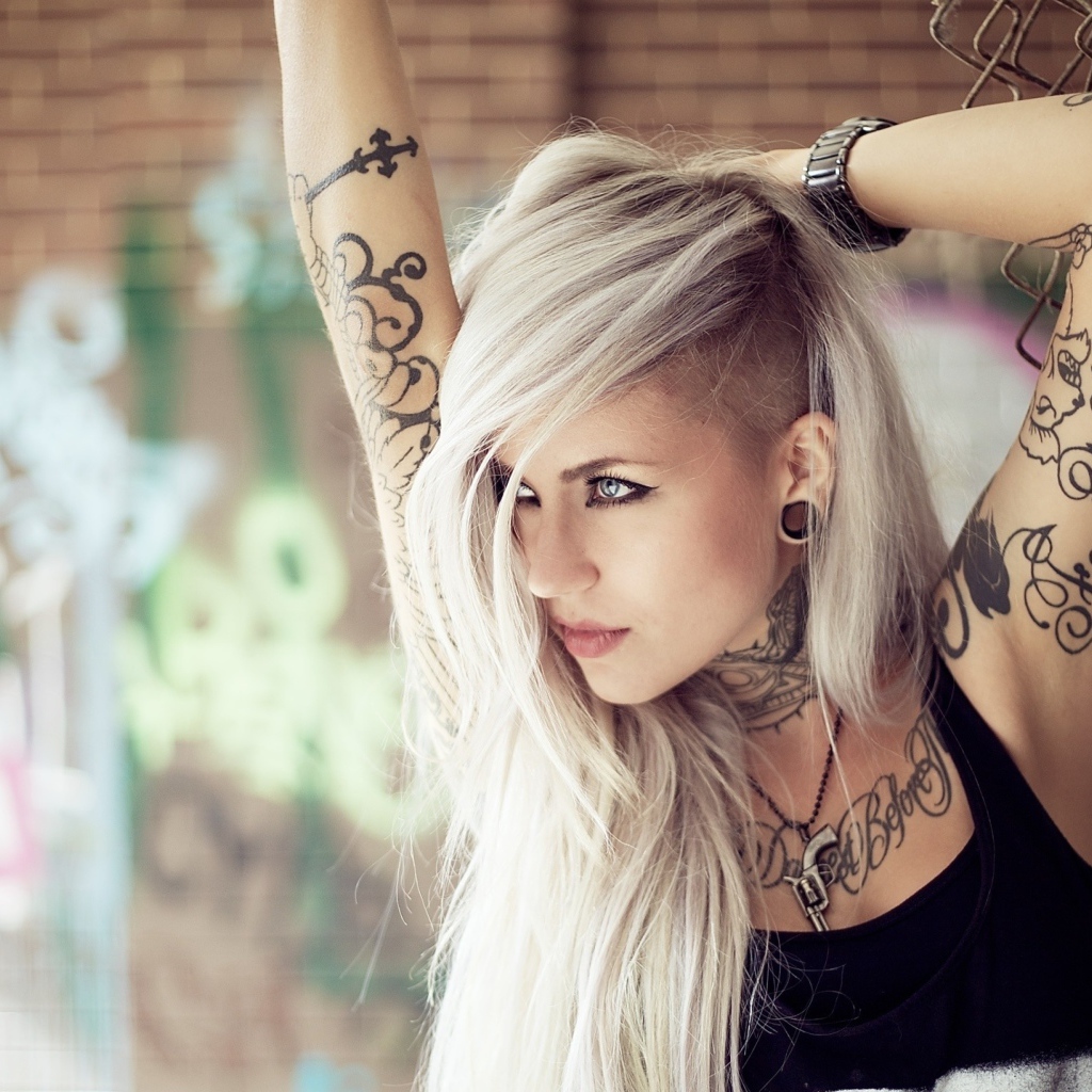 Красивая блондинка с татуировками на теле