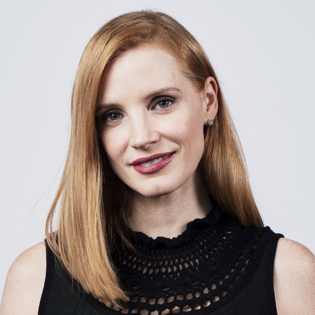 Красивая рыжеволосая актриса Джессика Честейн на сером фоне