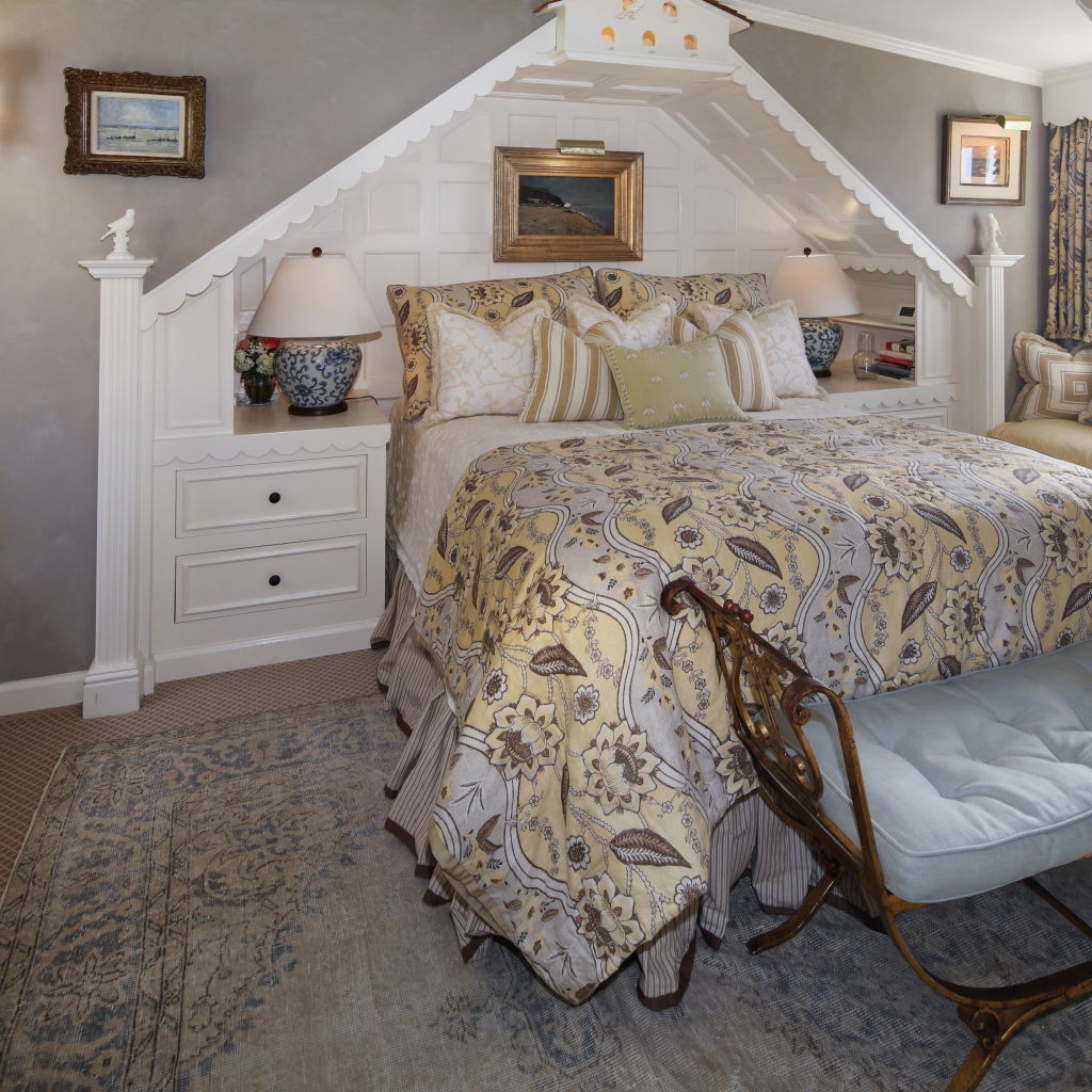 Спальня с большой просторной кроватью и диваном у окна 