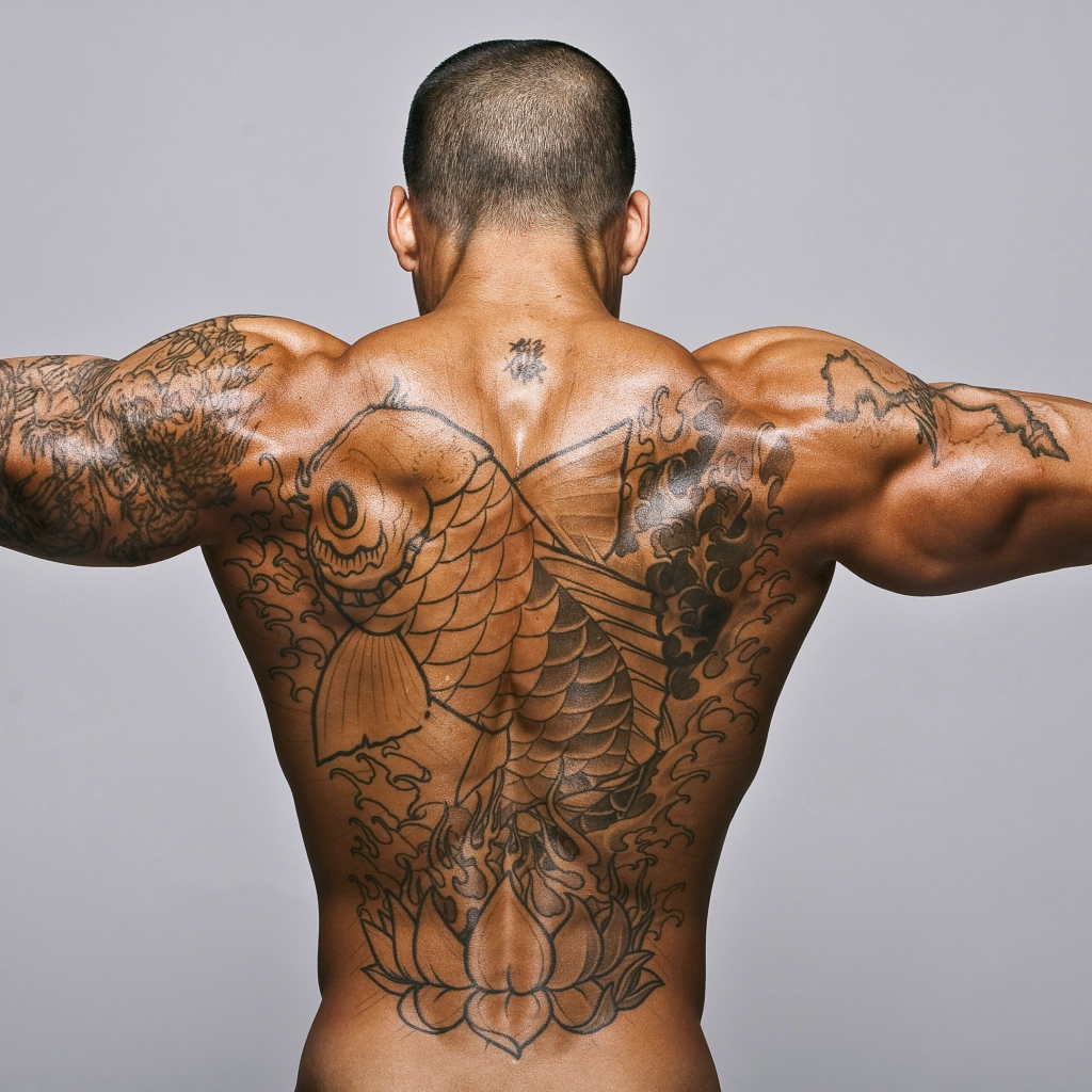 Большая татуировка с рыбой на спине у мужчины