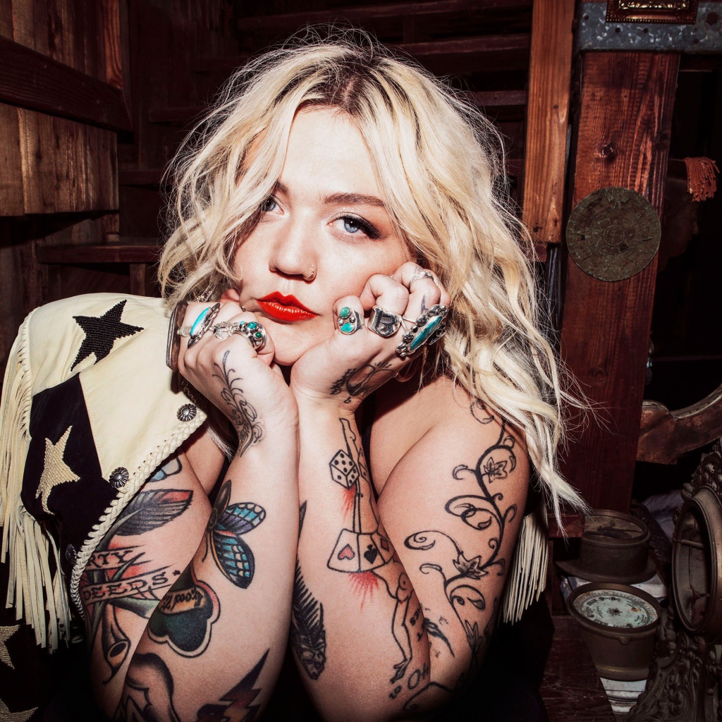 Голубоглазая блондинка с татуировками на руках
