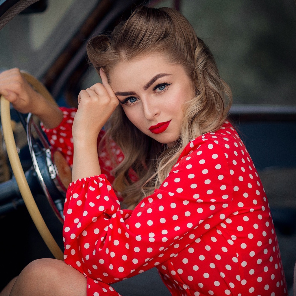 Blue-eyed retro girl driving a car