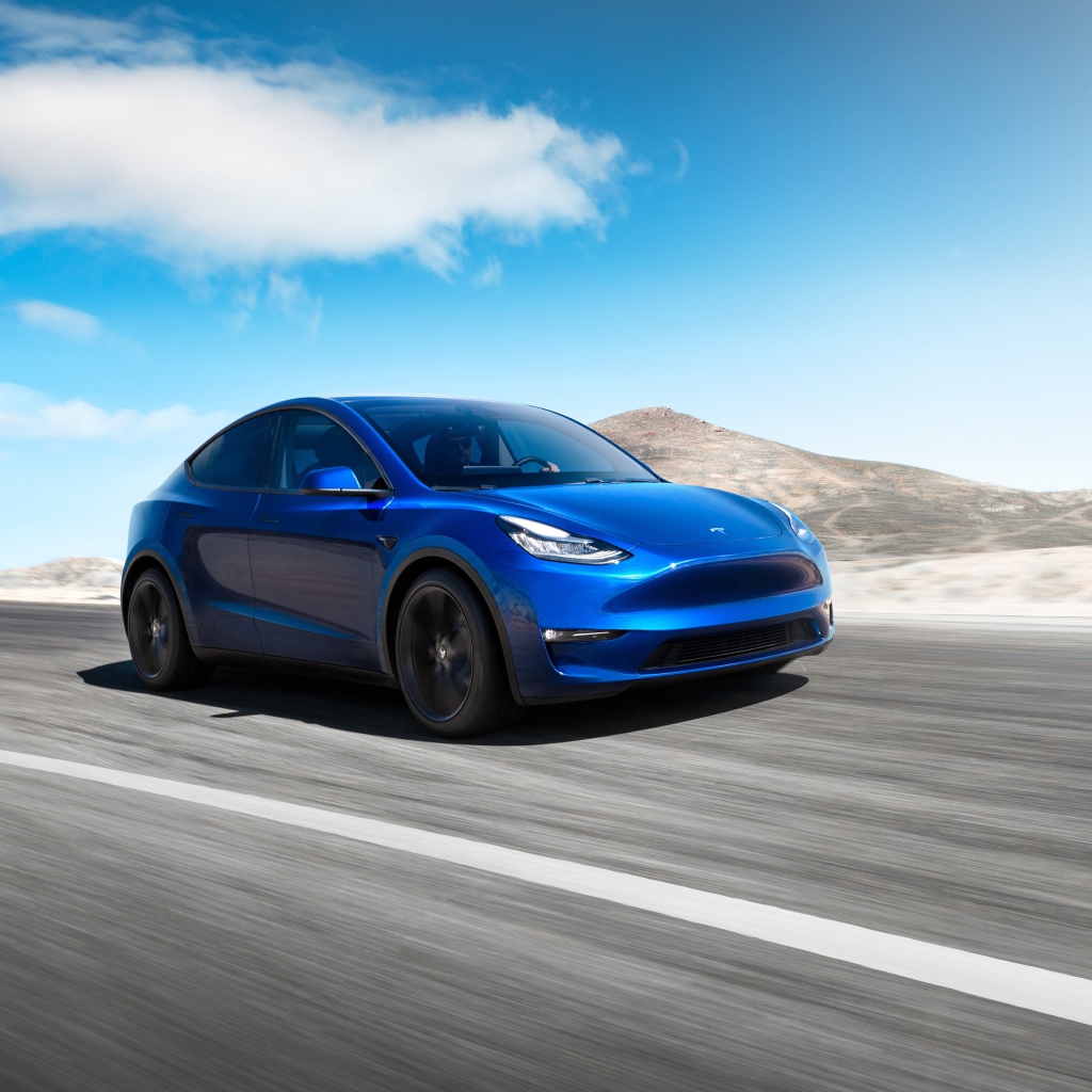 Синий автомобиль Tesla Model Y 2020 года на фоне голубого неба