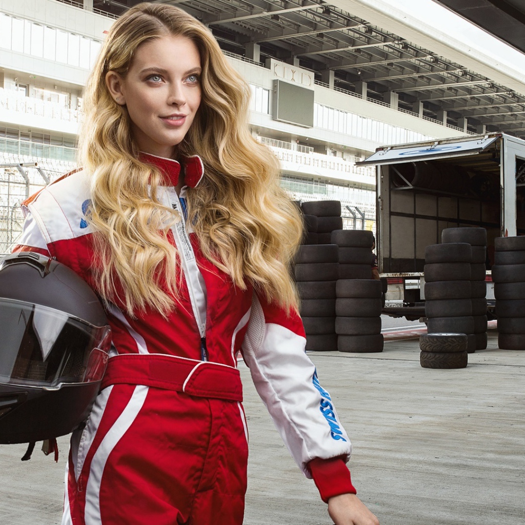 Девушка гонщица с шлемом в руках