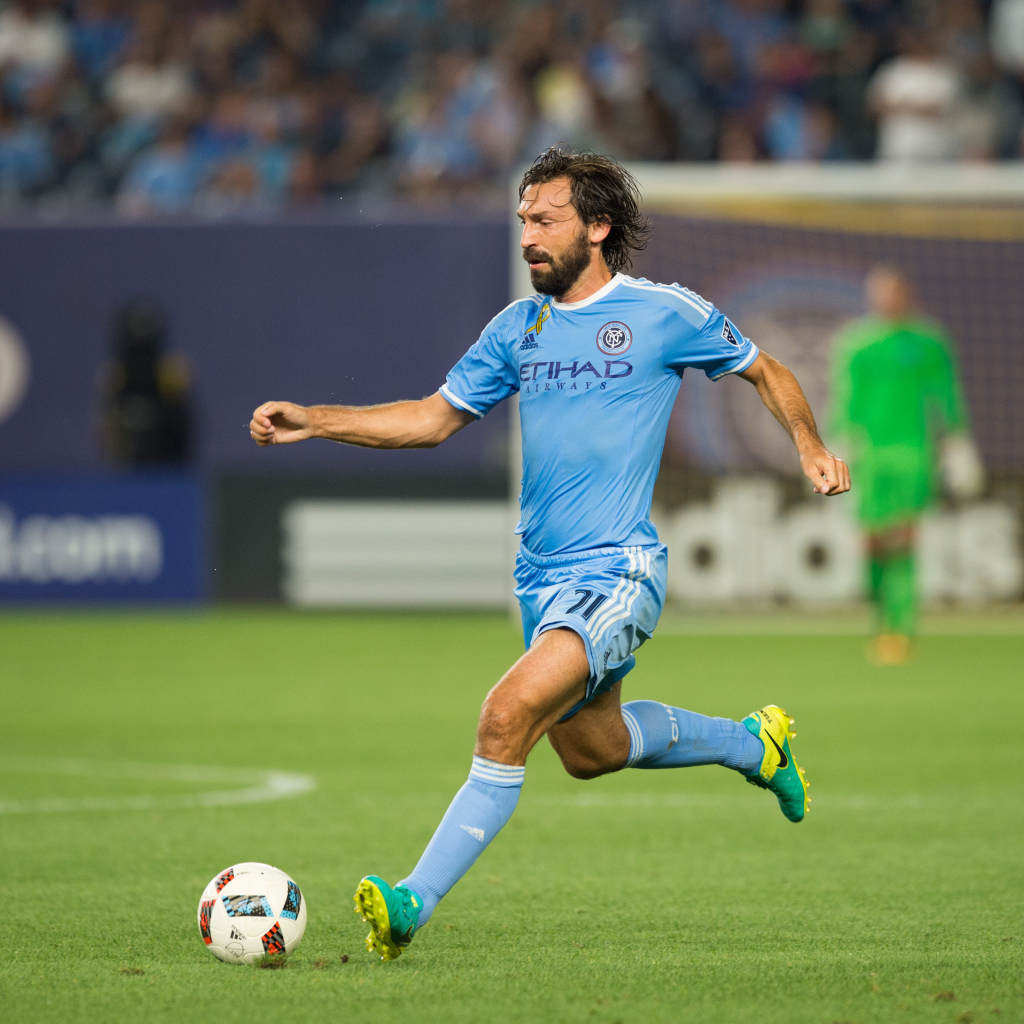 Итальянский футболист Андреа Пирло отбивает мяч на футбольном поле