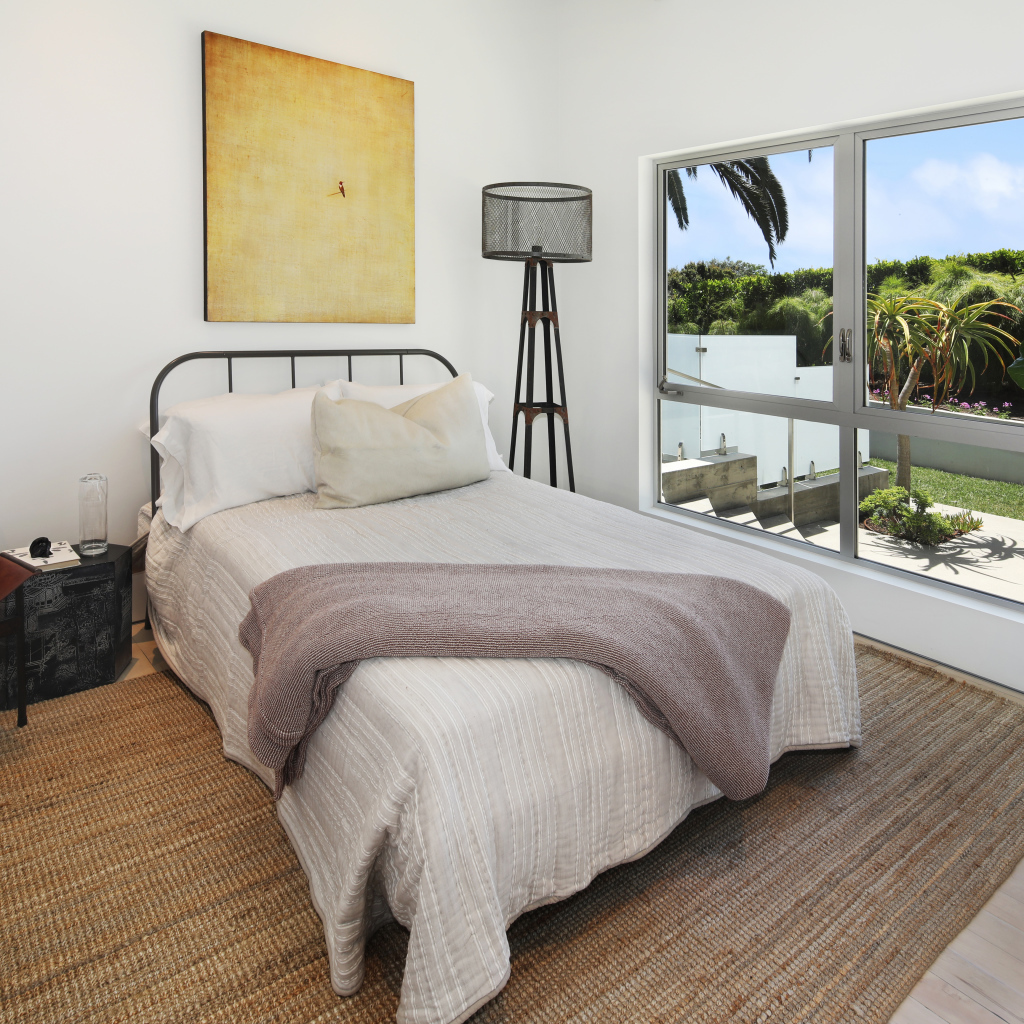 Большая кровать у окна в спальной комнате