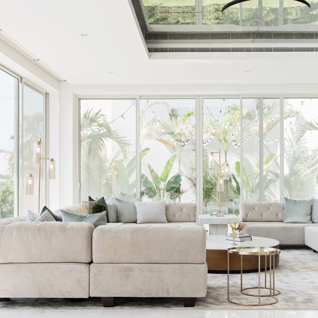 Большая гостиная комната с диваном и большими окнами