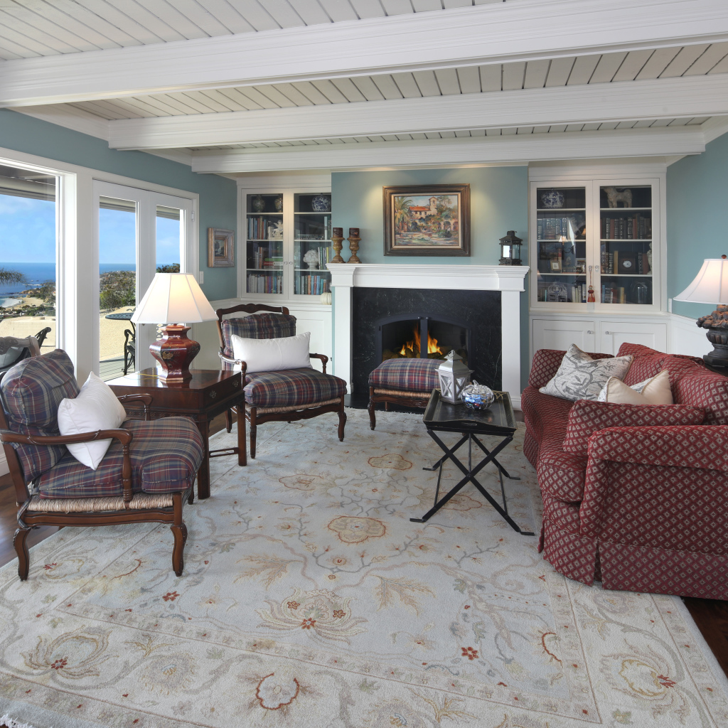 Гостиная комната с большим мягким диваном, креслами и камином 