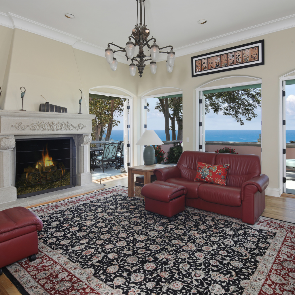 Гостиная с кожаным диваном, большими окнами и камином 