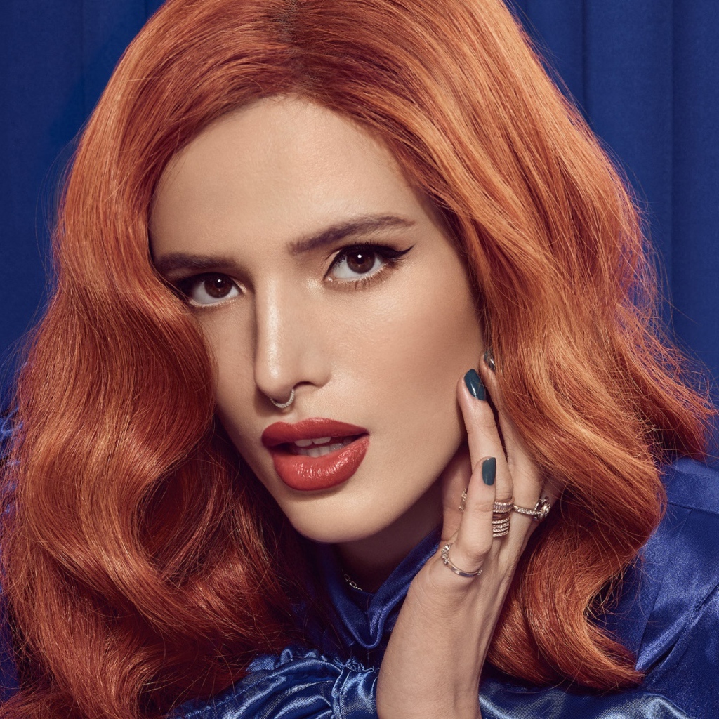 Рыжеволосая актриса Белла Торн на синем фоне