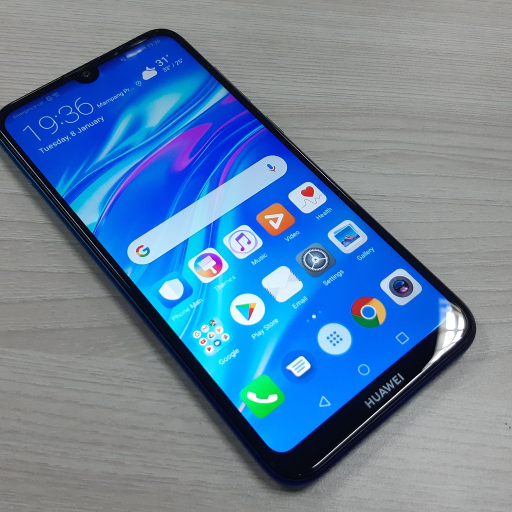 Смартфон Huawei Y7 Pro, 2019 года лежит на деревянном столе