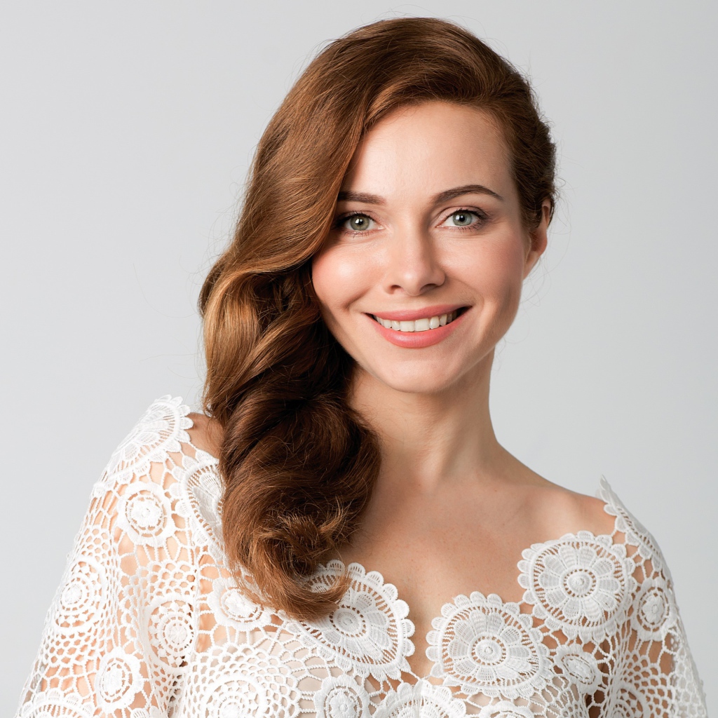 Улыбающаяся милая девушка, актриса Екатерина Гусева на сером фоне