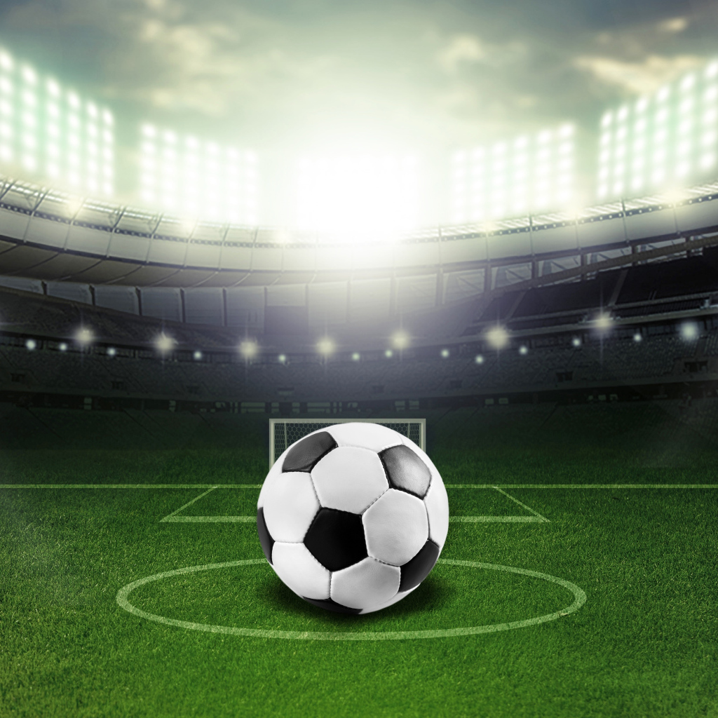 Футбольный мяч лежит на футбольном поле на стадионе