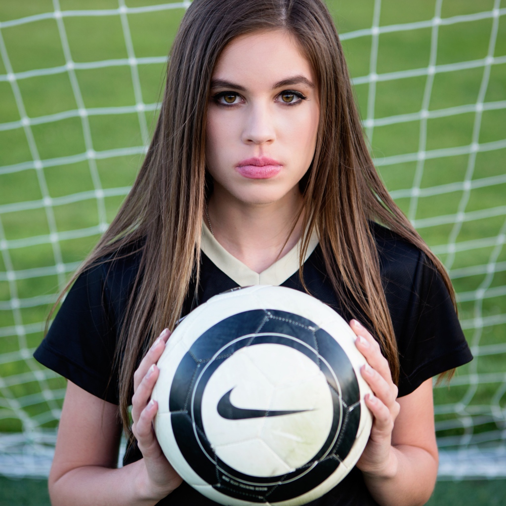 Спортивная девушка вратарь с мячом в воротах 