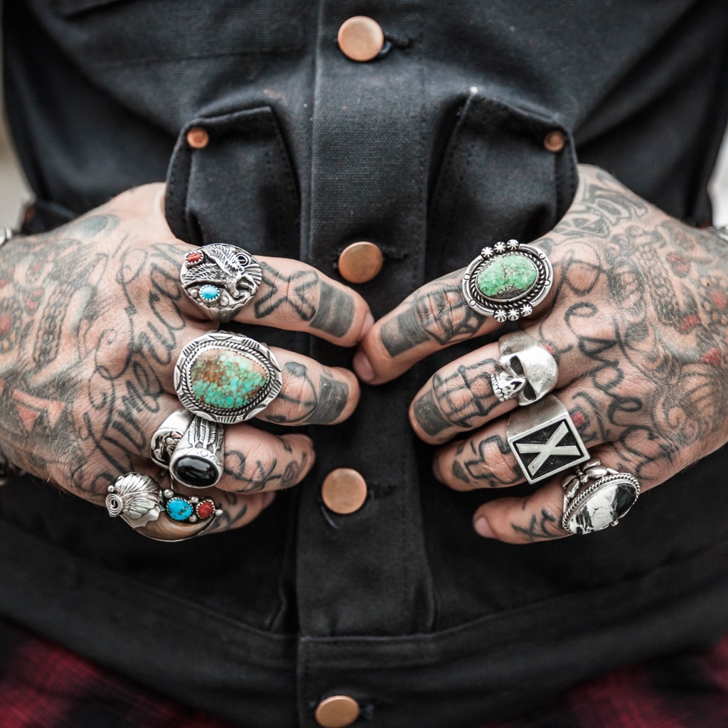 Tattoos on the hands of men with rings