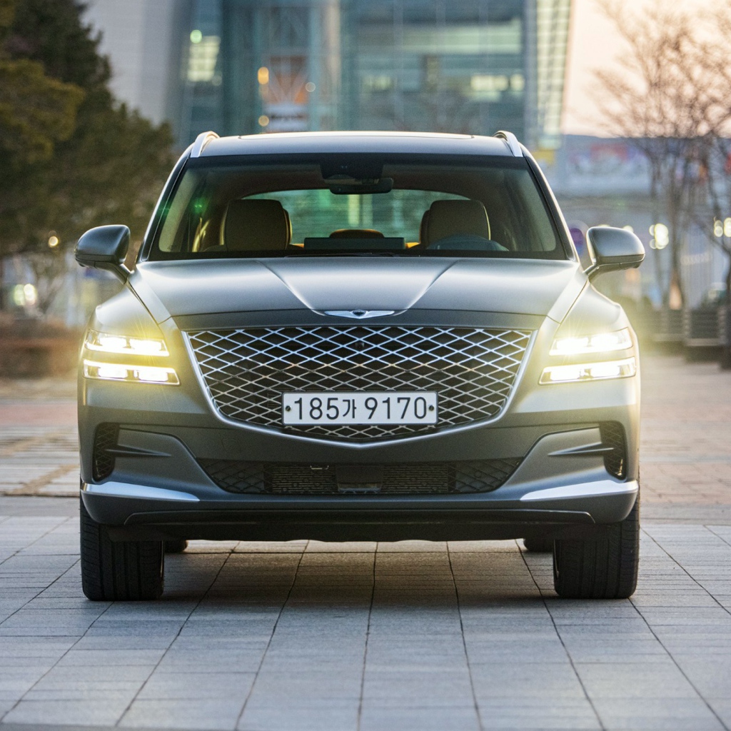 Автомобиль Genesis GV80,  2020 года с включенными фарами