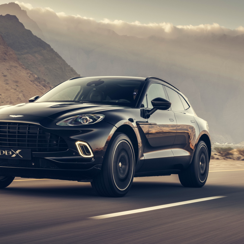 Черный автомобиль Aston Martin DBX 2020 года на трассе