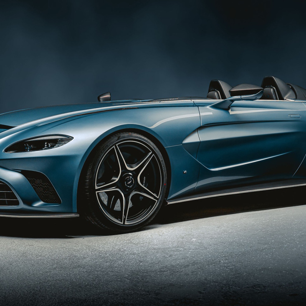 Синий автомобиль Aston Martin V12 Speedster 2020 года на сером фоне