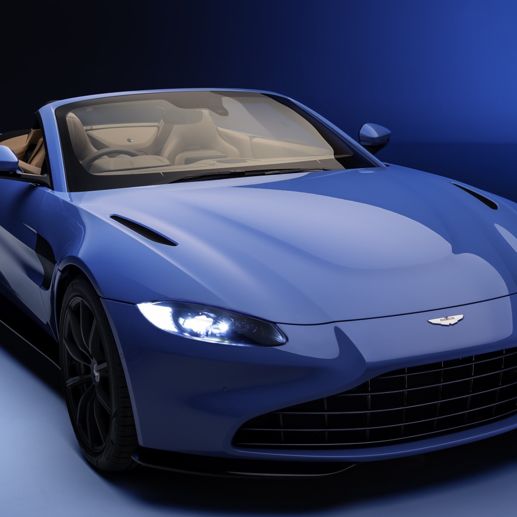 Кабриолет Aston Martin Vantage Roadster 2020 года на синем фоне