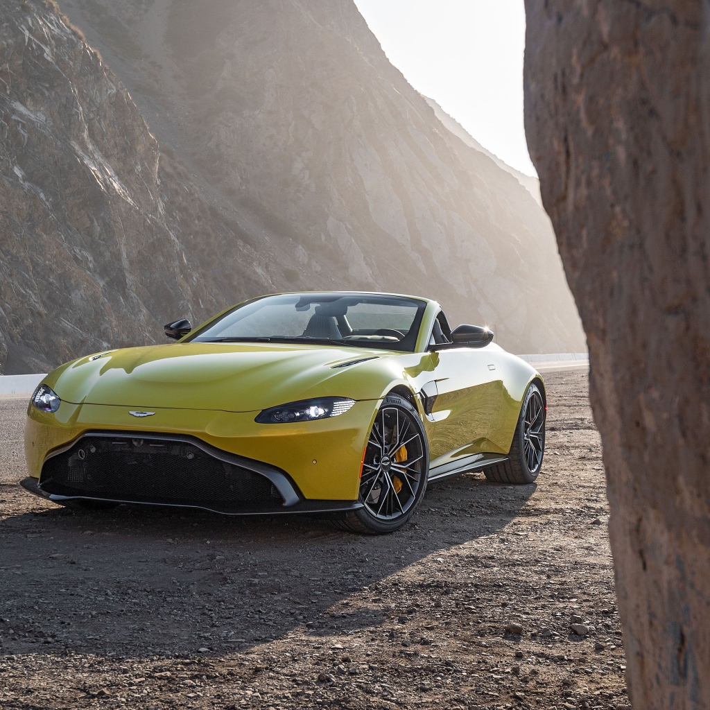 Желтый автомобиль  Aston Martin Vantage Roadster, 2021 года в горах 