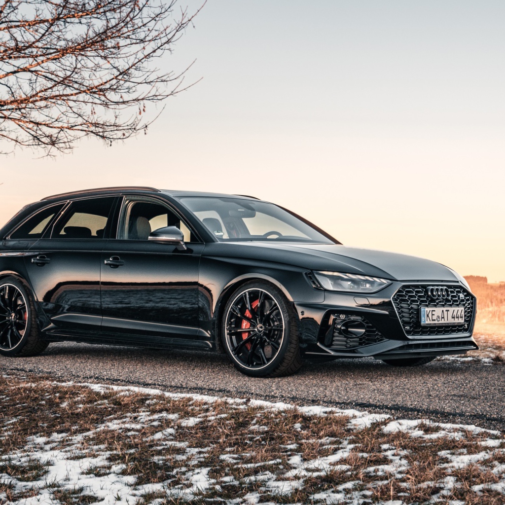 Черный автомобиль  Audi RS 4 Avant 2020 года на дороге у дерева
