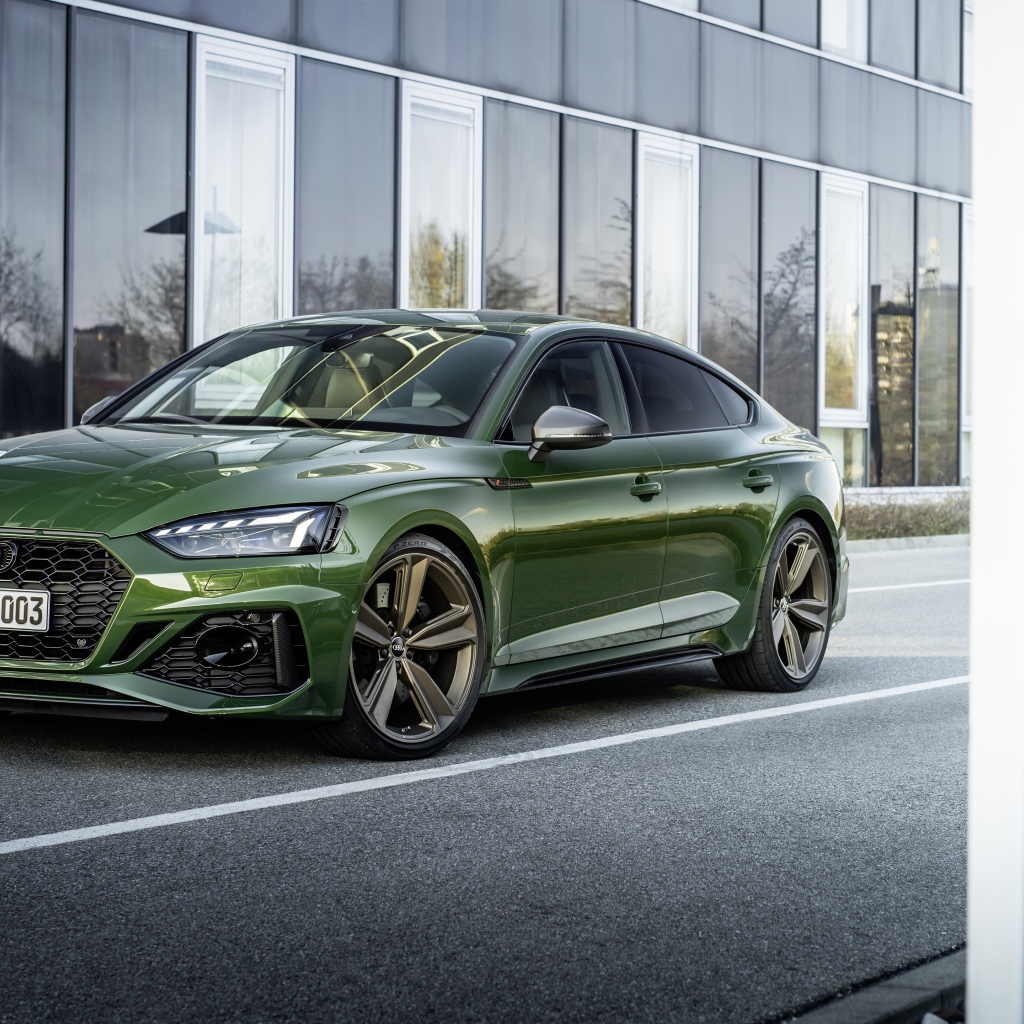 Зеленый автомобиль Audi RS 5 Sportback 2020 года у здания 