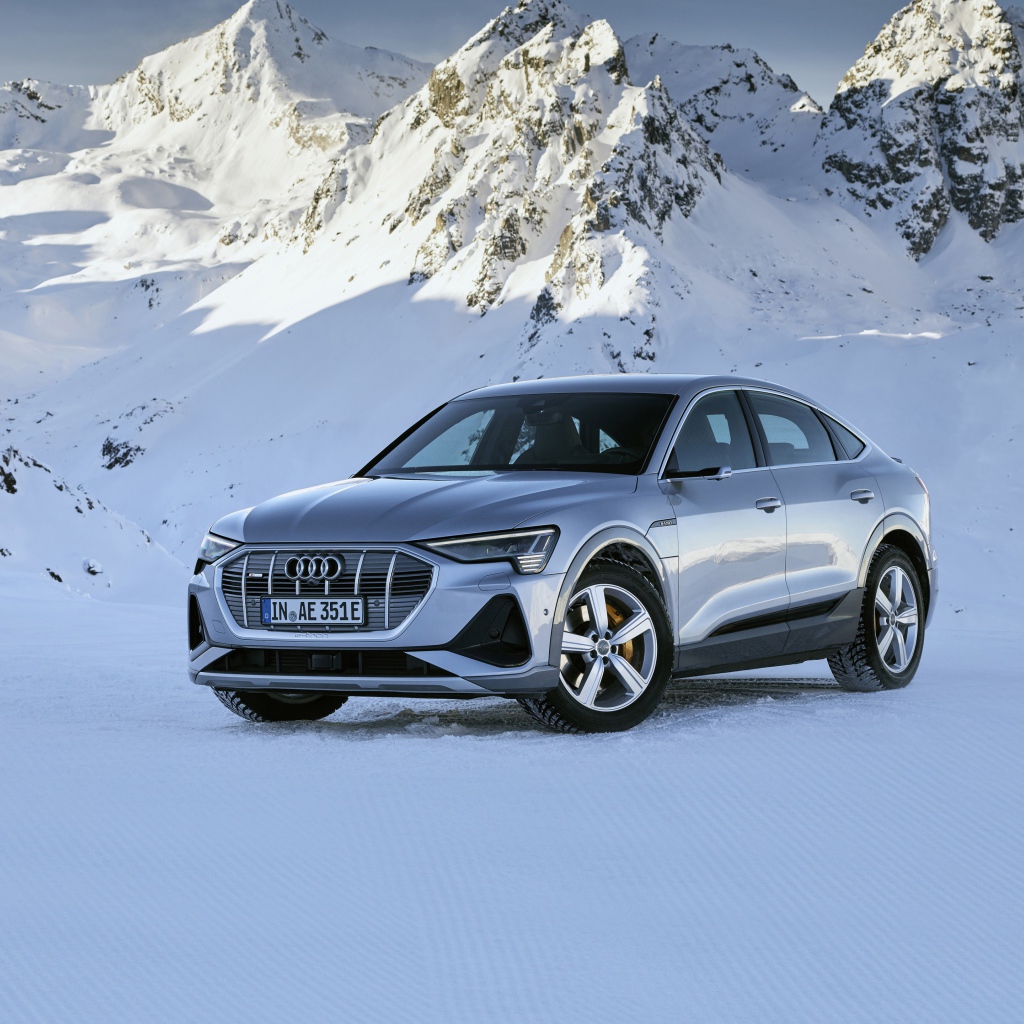 Автомобиль Audi E-Tron 55 Quattro Sportback S Line, 2020 года на фоне заснеженных гор 