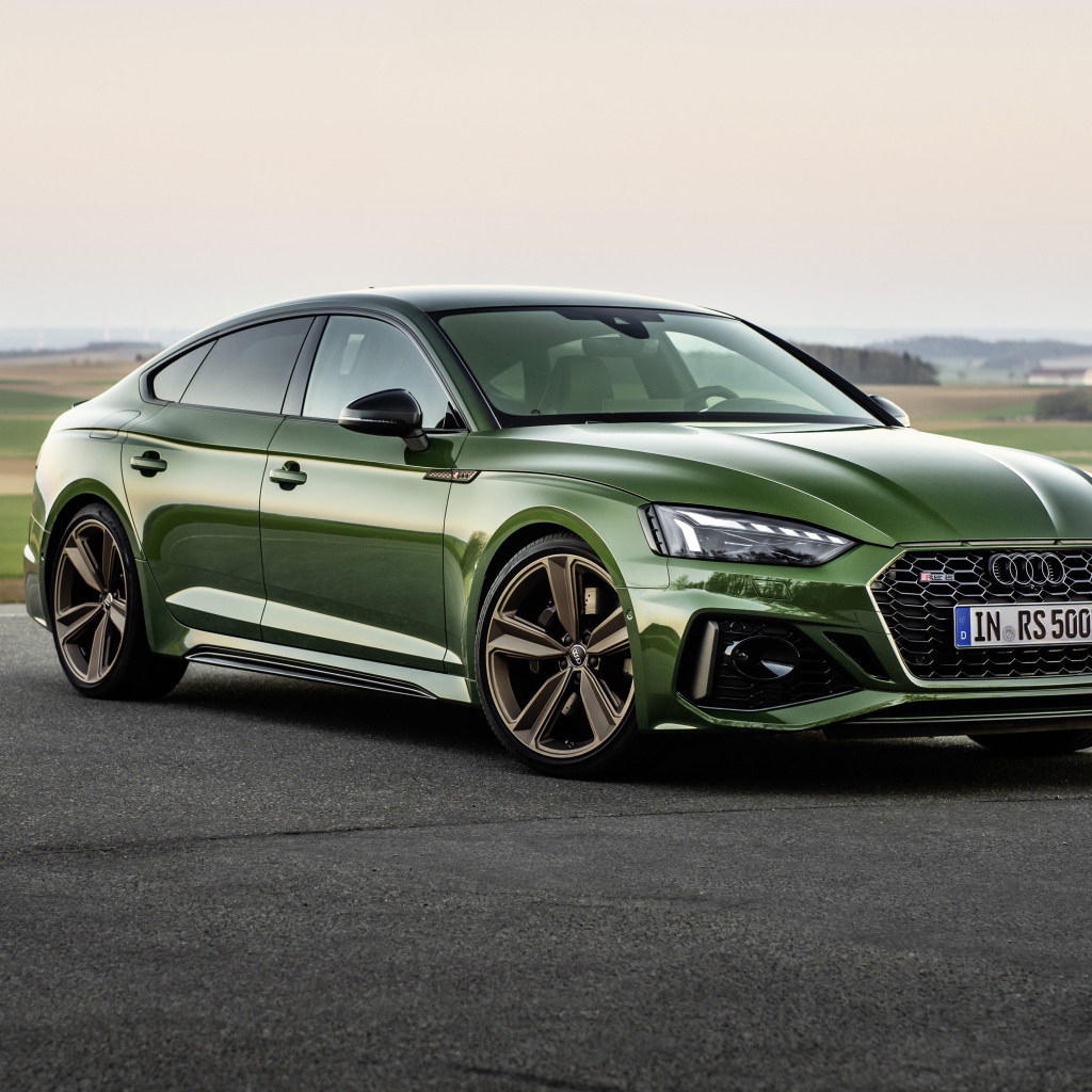 Зеленый автомобиль Audi RS 5 Sportback 2020 года на фоне поля