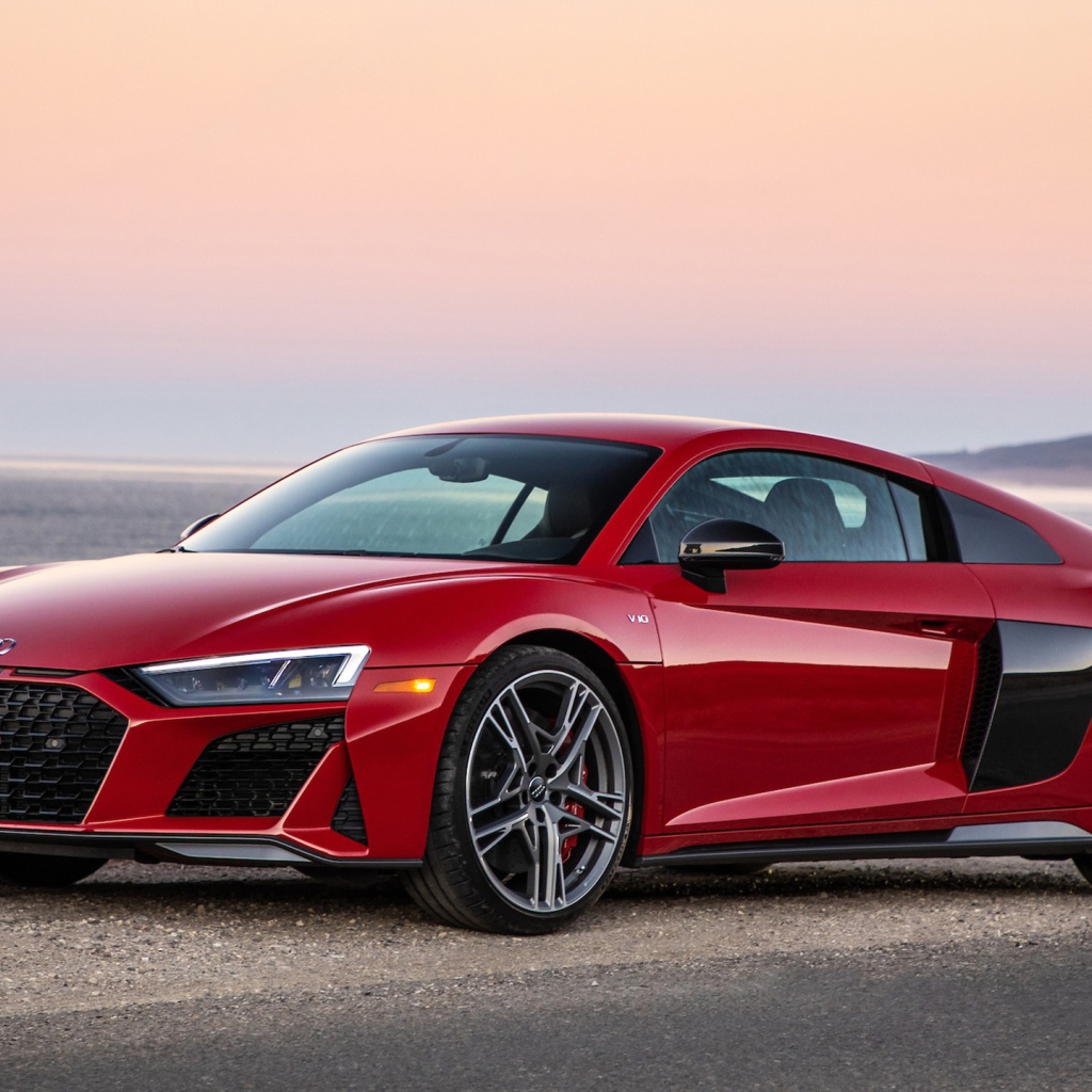 Красный спортивный автомобиль Audi R8 V10, 2020 года на фоне океана