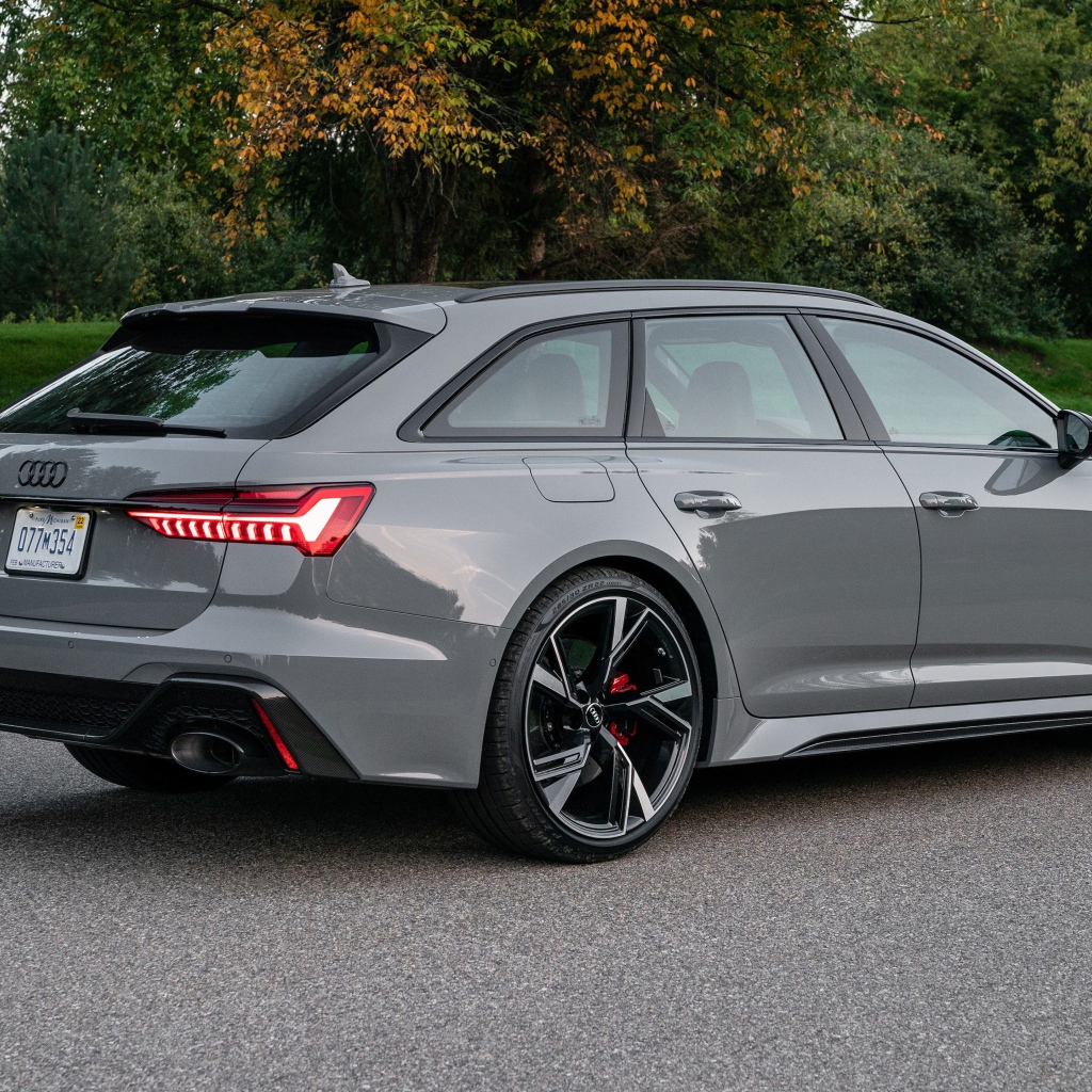 Серебристый автомобиль Audi RS 6 Avant, 2021 года вид сзади