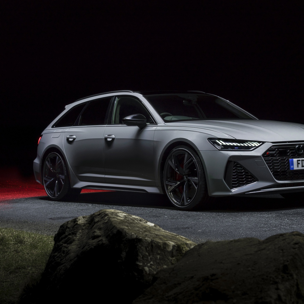 Серебристый автомобиль Audi RS 6 Avant 2020 года на дороге ночью 