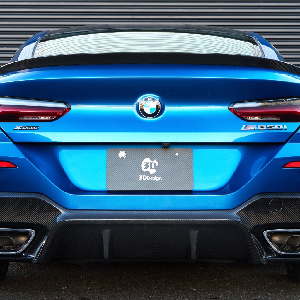 Синий автомобиль BMW M850i XDrive Coupe 2020 года вид сзади