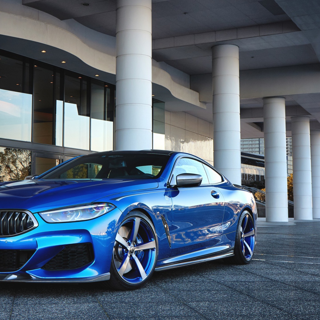 Синий автомобиль BMW M850i XDrive Coupe 2020 года у здания 