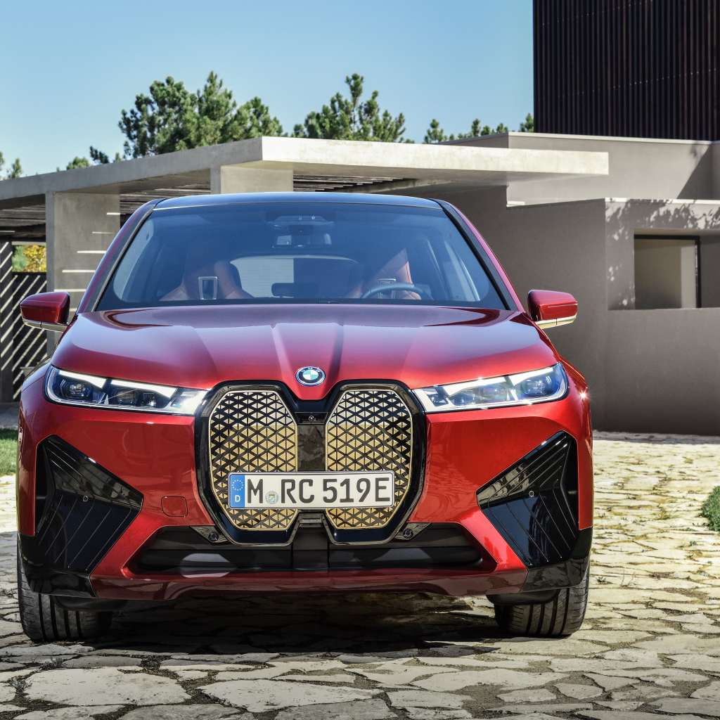Красный автомобиль BMW IX 2021 года у дома