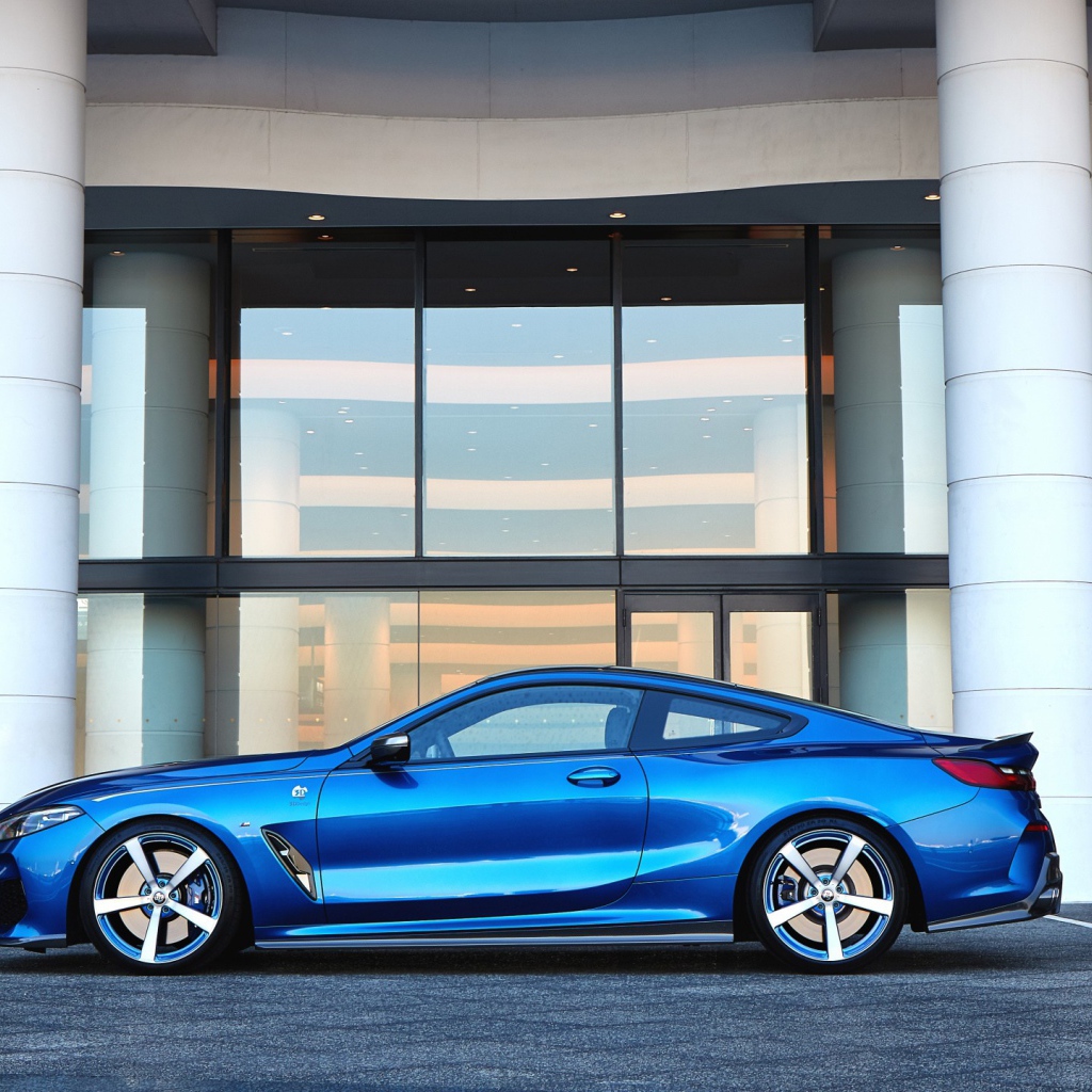 Голубой автомобиль BMW M850i XDrive Coupe 2020 года у здания 