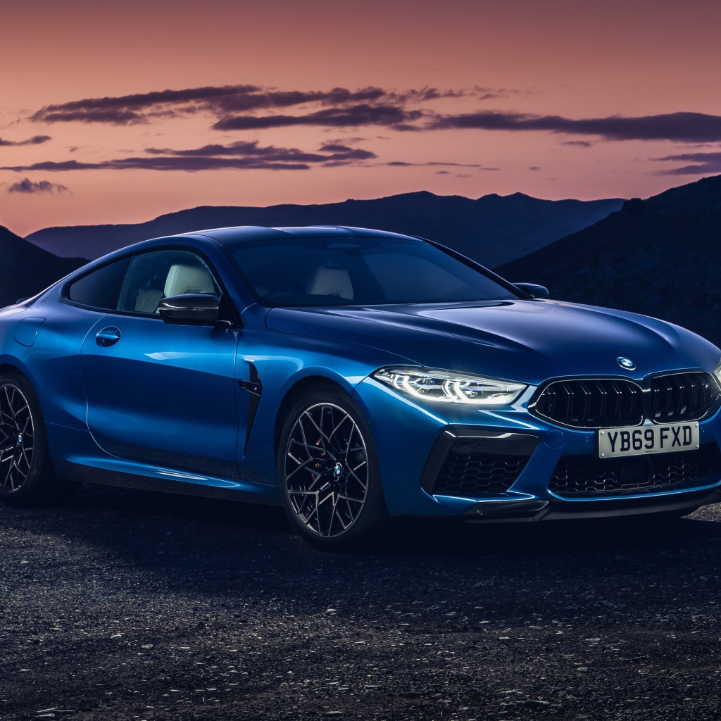 Синий автомобиль BMW M8, 2019 года на фоне гор