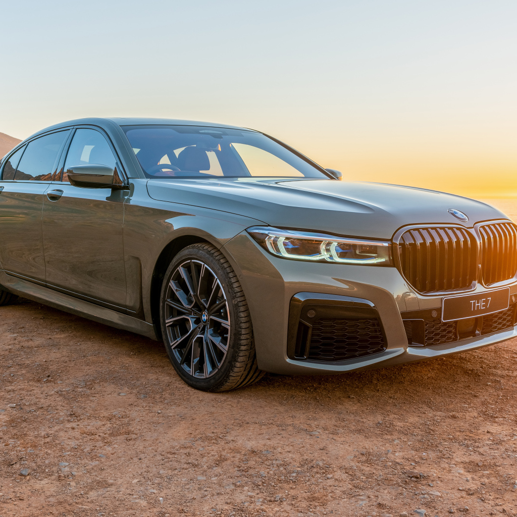 Стильный дорогой автомобиль BMW 745Le , 2020 года на фоне заката