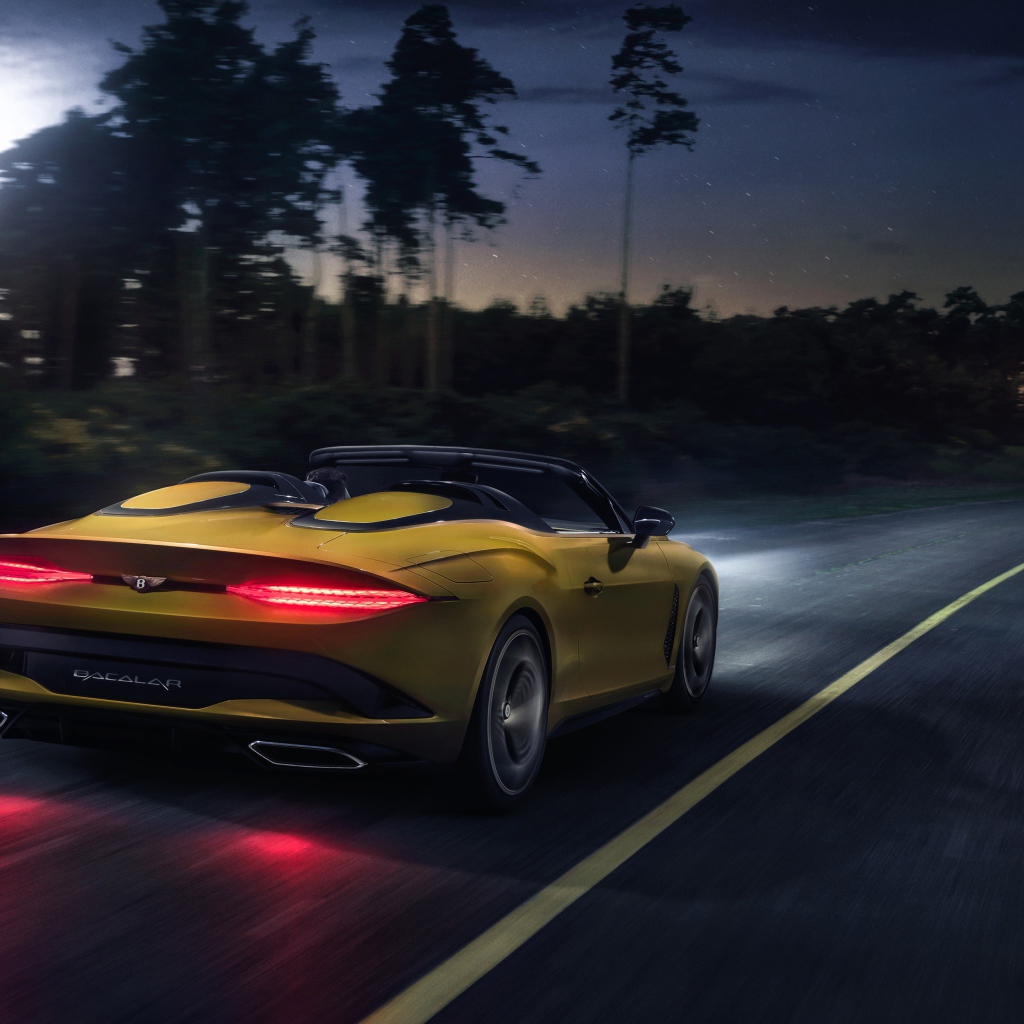Желтый автомобиль Bentley Mulliner Bacalar 2020 года на ночной трассе 