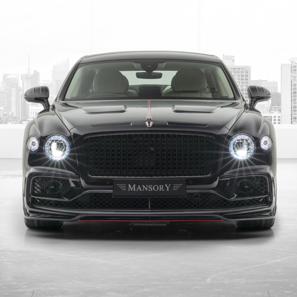 Черный автомобиль Mansory Bentley Flying Spur 2020 года с включенными фарами 