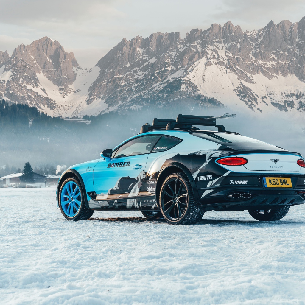Автомобиль bentley continental gt, 2020 года на фоне заснеженных гор 