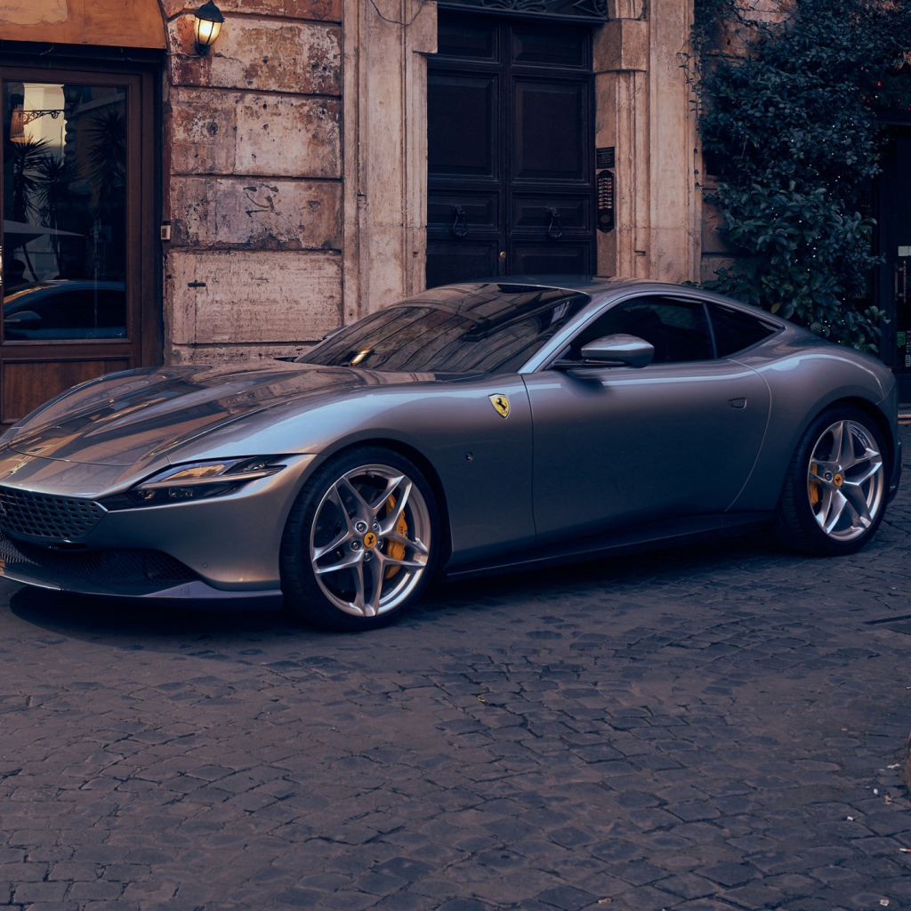 Серебристый автомобиль Ferrari Roma 2020 года у кафе