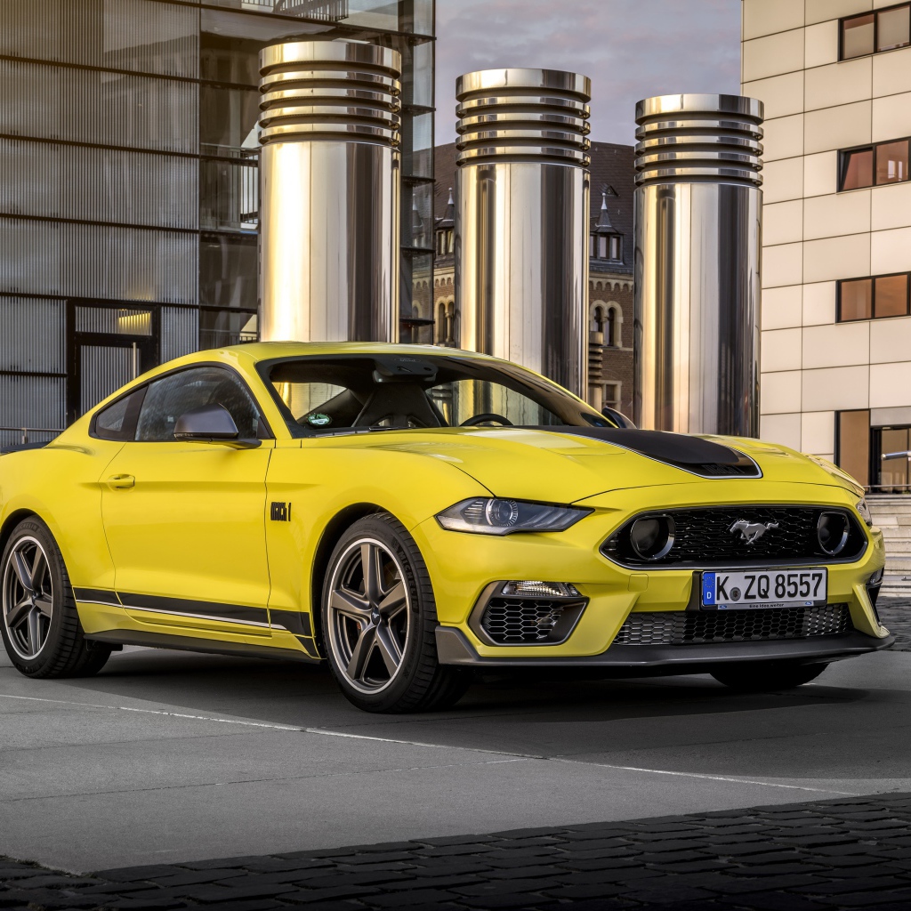Быстрый желтый автомобиль Ford Mustang Mach 1 2021 года у здания 