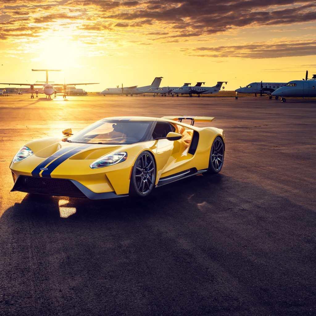 Желтый спортивный автомобиль Ford GT на закате