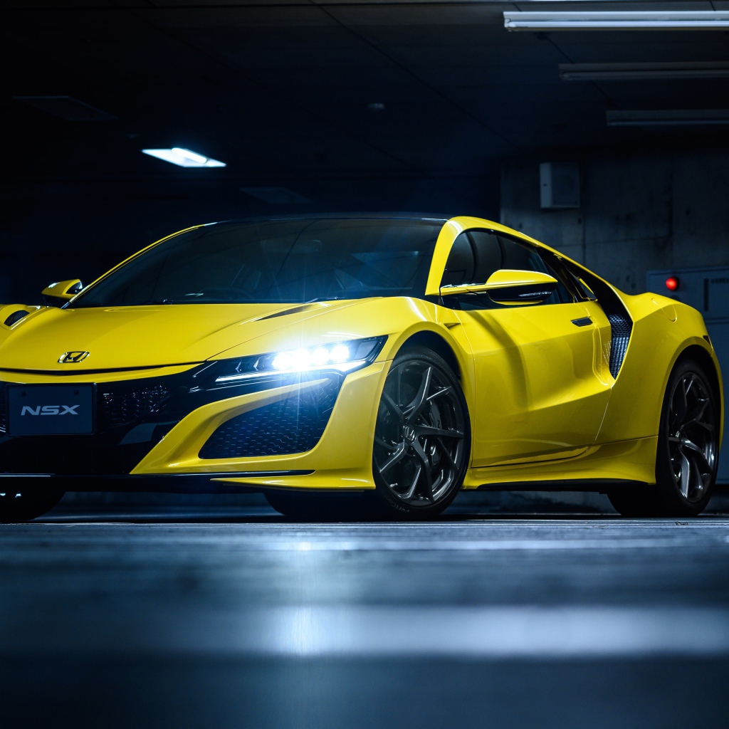 Желтый автомобиль Honda NSX с включенными фарами 