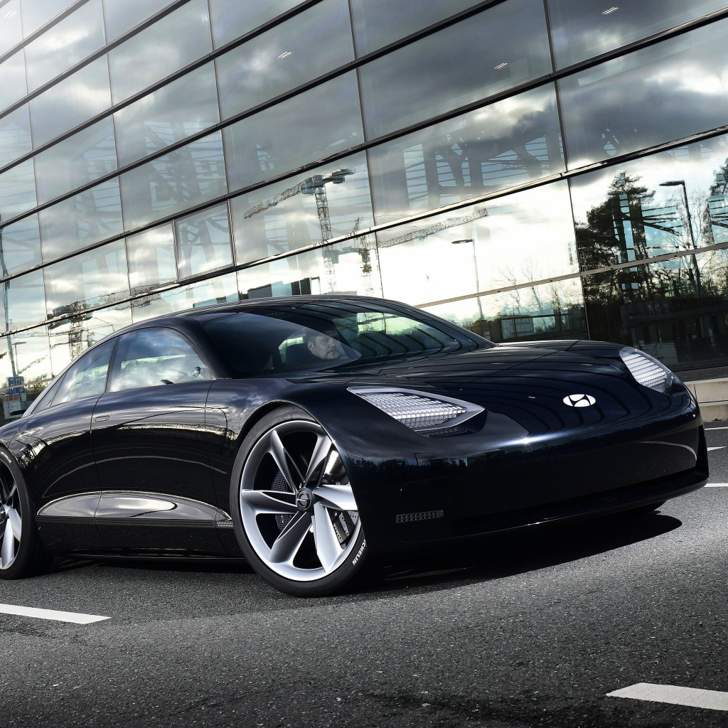 Черный автомобиль Hyundai Prophecy 2020 года у стеклянного здания 